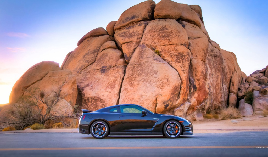 Черный Nissan GT-R у подножия скалы
