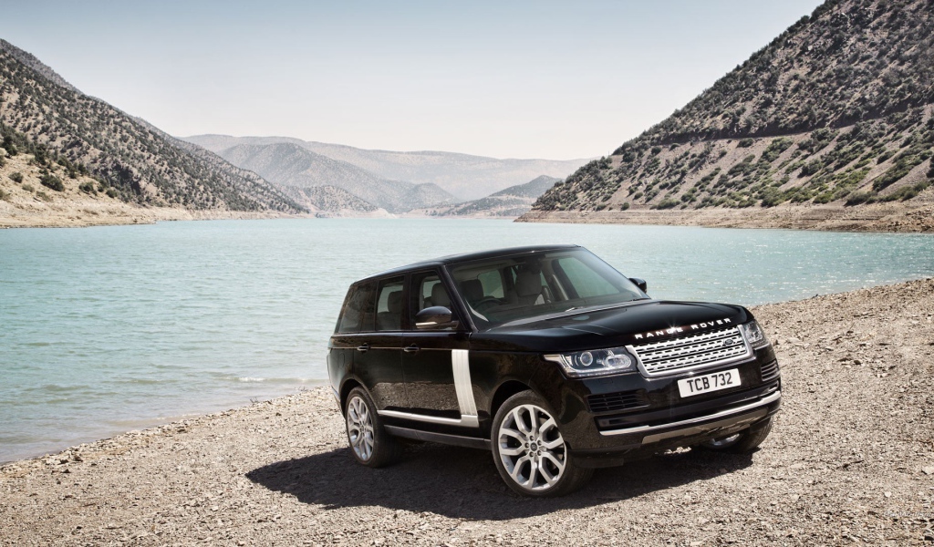 Черный Range Rover на берегу водоема
