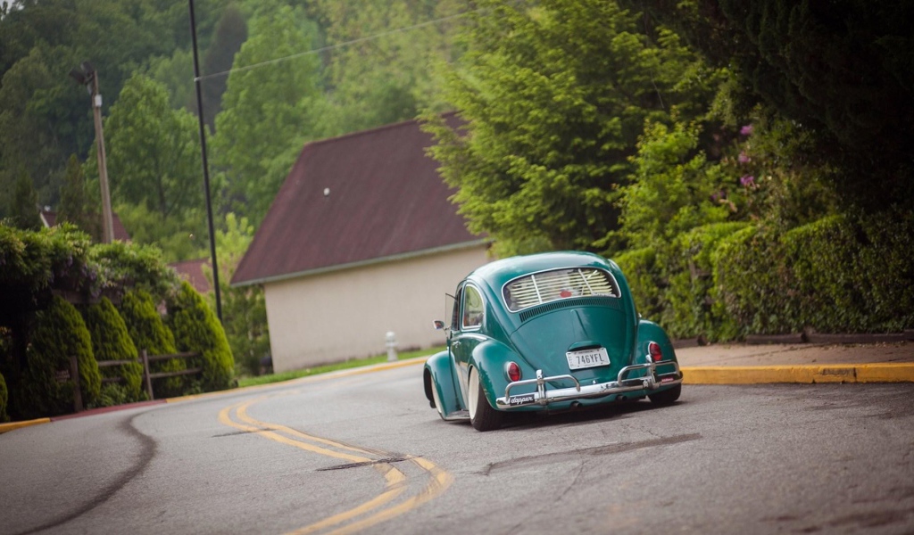 Зеленый Volkswagen Beetle на дороге