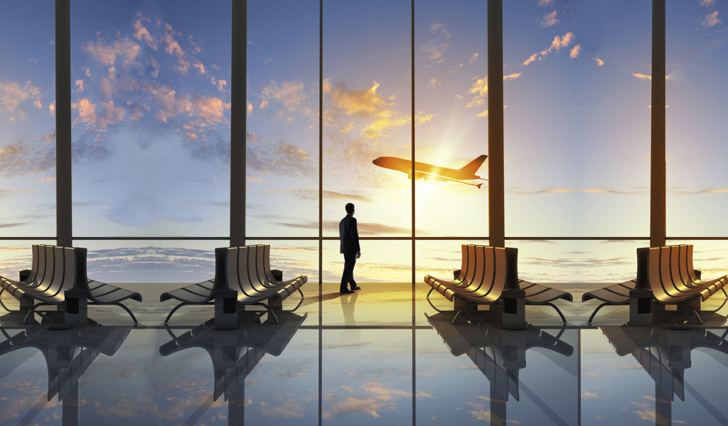 Мужчина смотрит в окно на взлетающий самолет