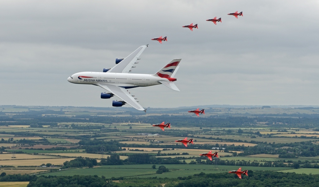 Airbus A380 в сопровождении красных истребителей