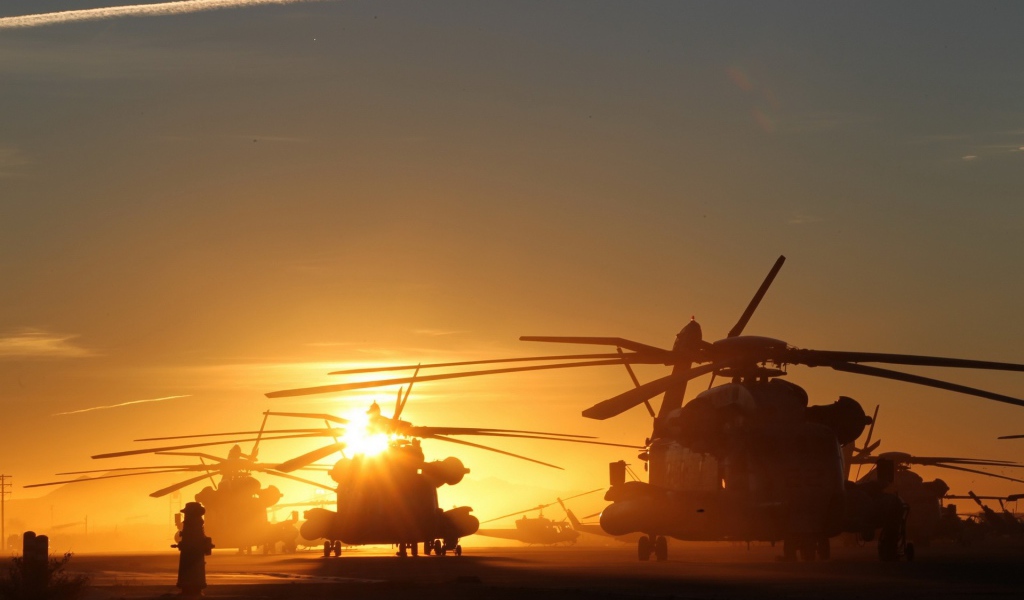 Несколько вертолетов на фоне заката