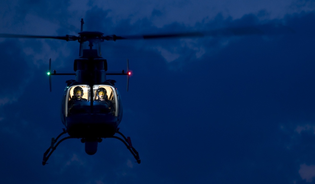 Двое в вертолете на фоне синего неба