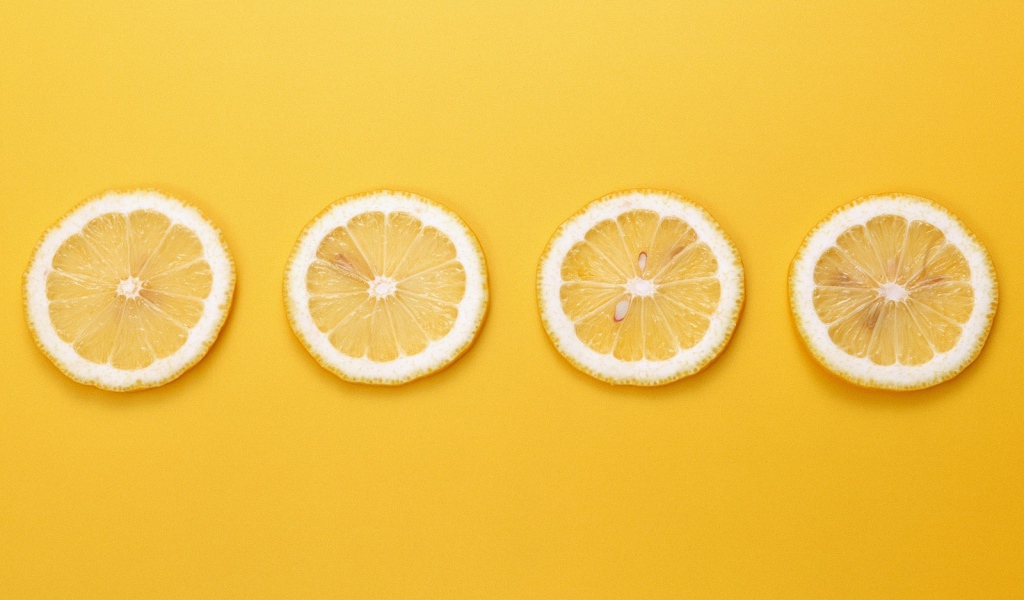 Кружки лимона, желтый фон