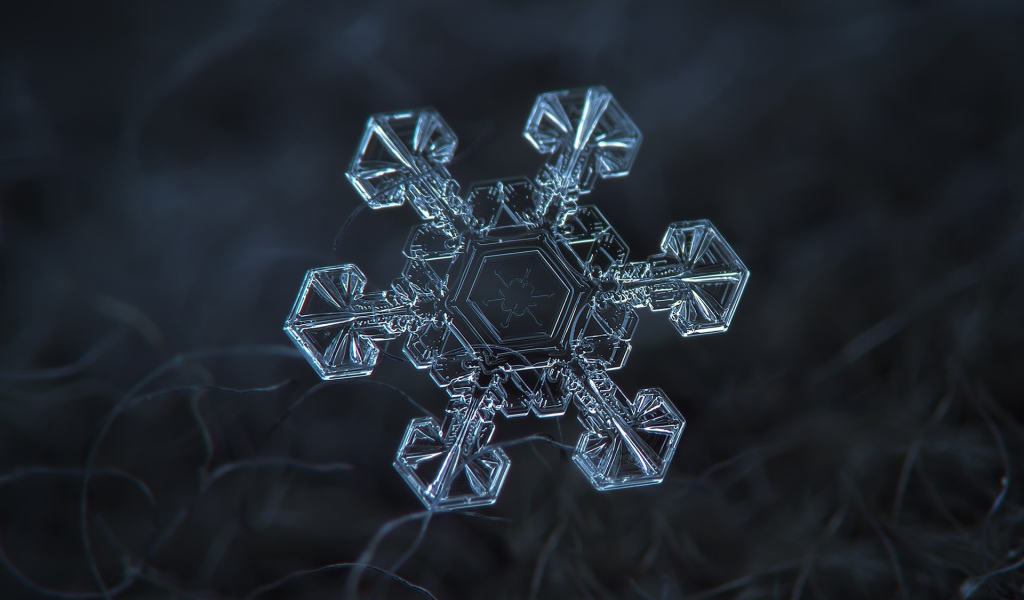 Снежинка под увеличением на черном фоне