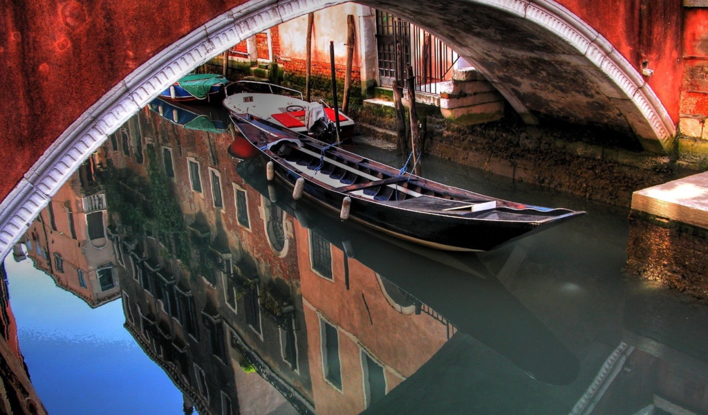 Лодка под красным мостом в Венеции