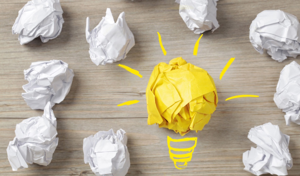 Комок желтой бумаги среди белых