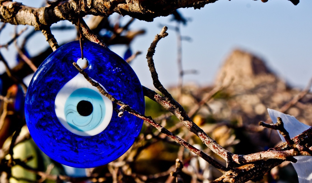 Оберег из синего стекла на дереве