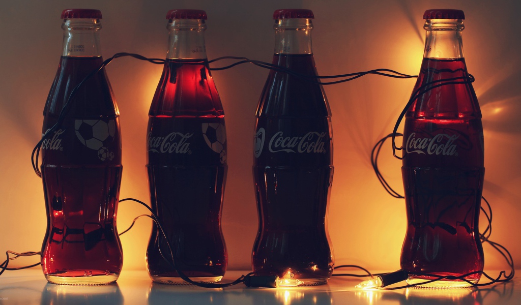 Бутылки Кока-Колы связанные новогодней гирляндой