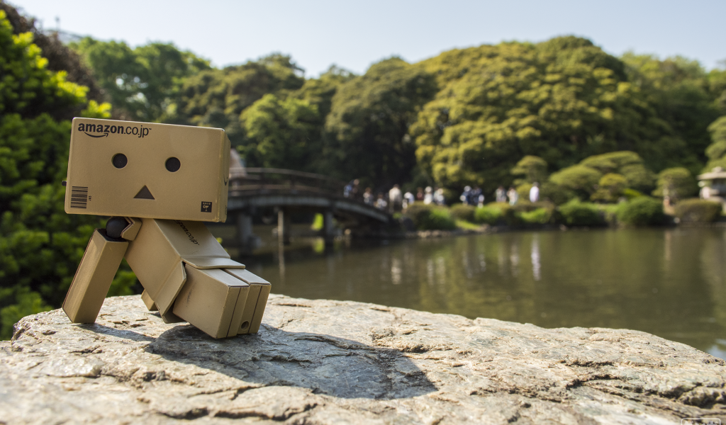 Картонный человечек на камне в саду