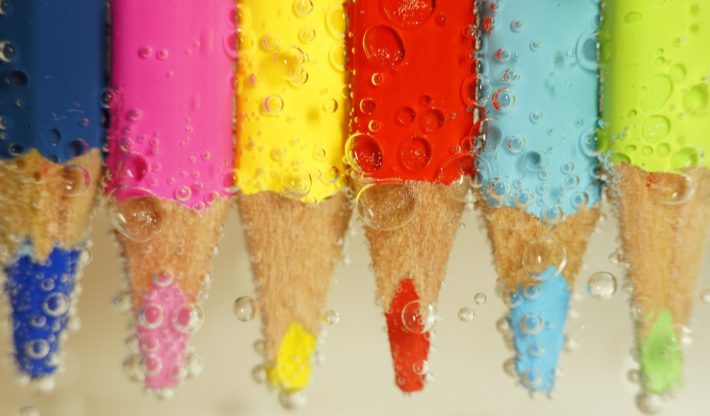 Карандаши в воде среди пузырей воздуха