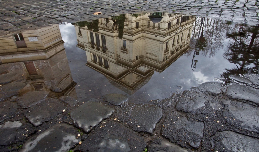 Отражение городского здания в луже