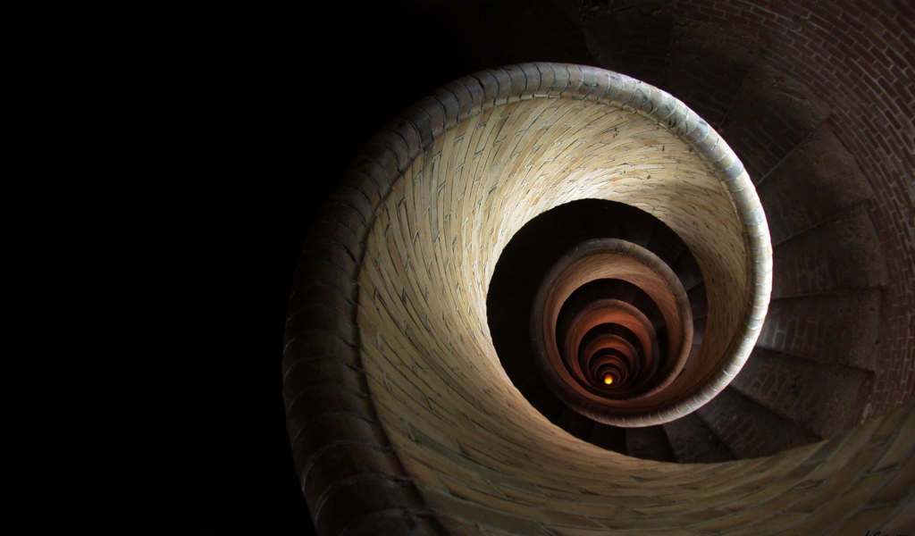 Спираль винтовой лестницы уходит вглубь