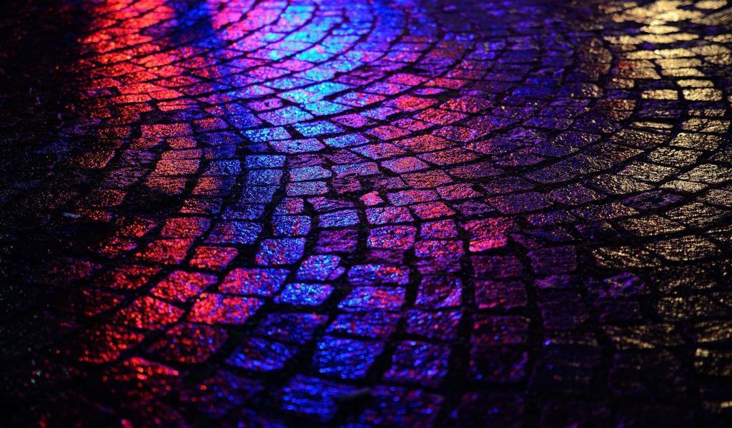 Блики ночных огней на брусчатке улицы