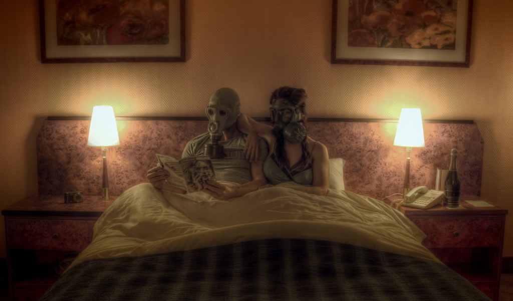 Семейная пара лежит в кровати в масках