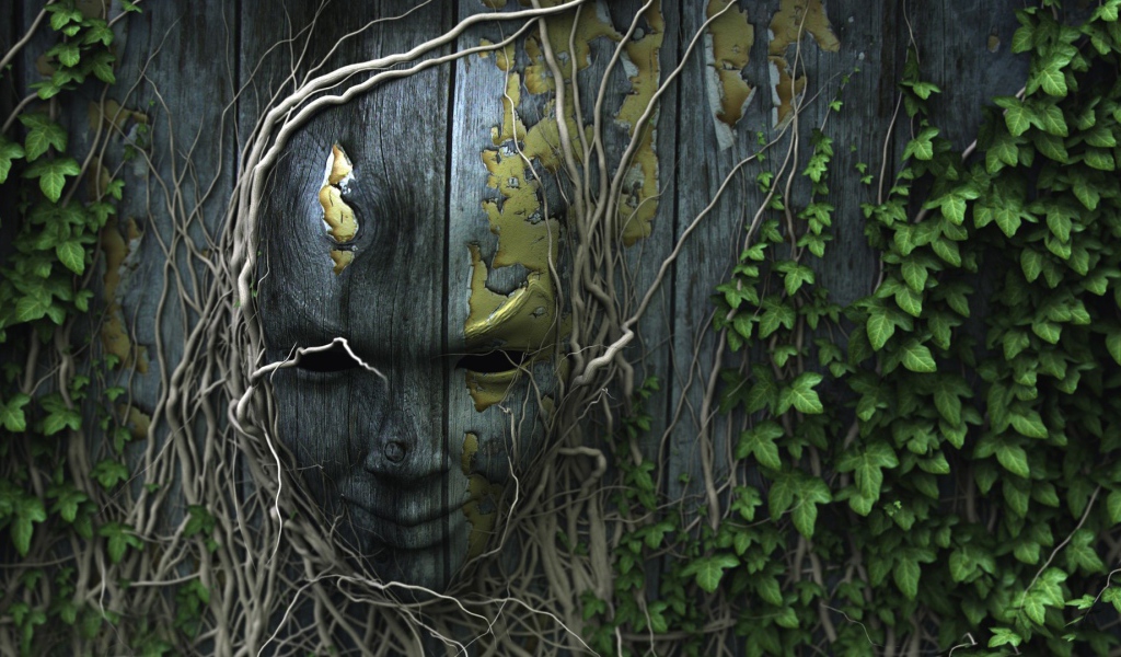 Лицо на деревянном заборе, увитое плющом