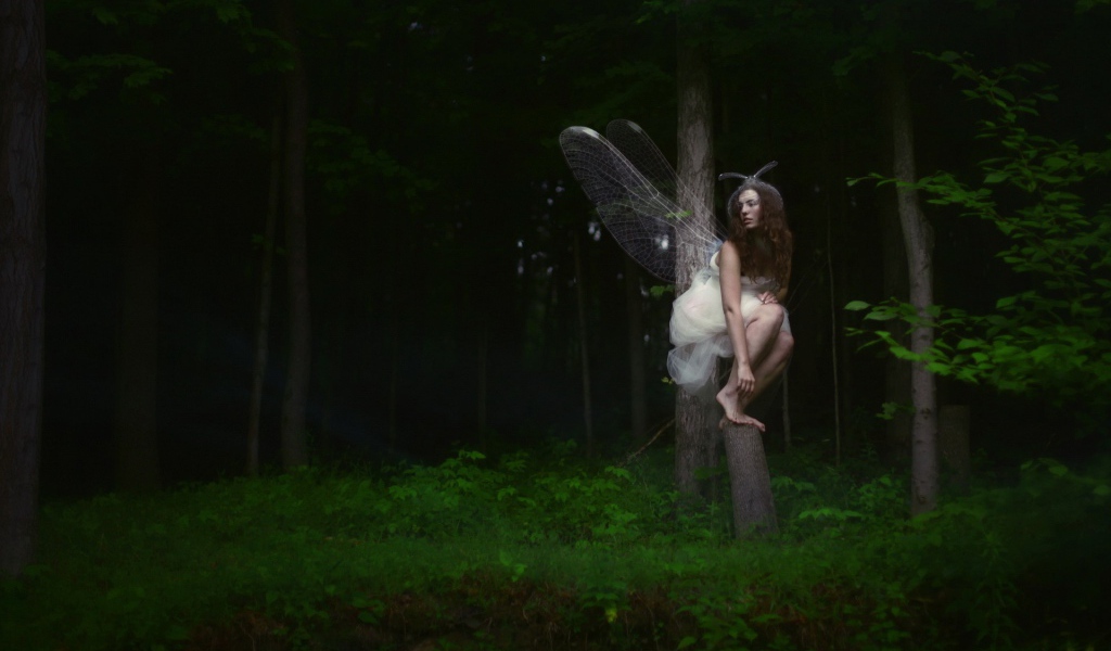 Девушка фея среди деревьев в чаще леса
