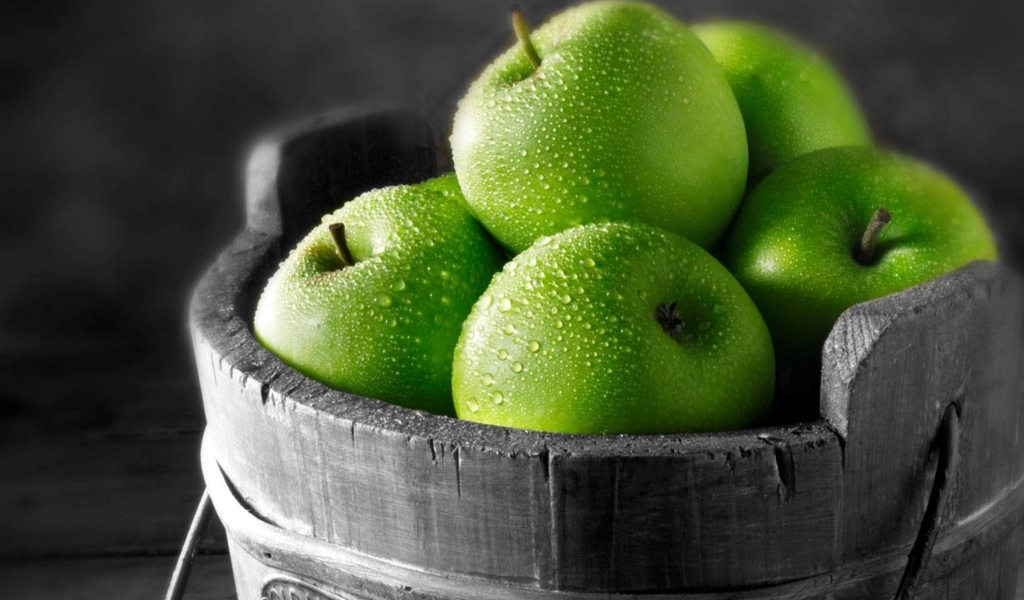 Ведро из дерева с зелеными яблоками