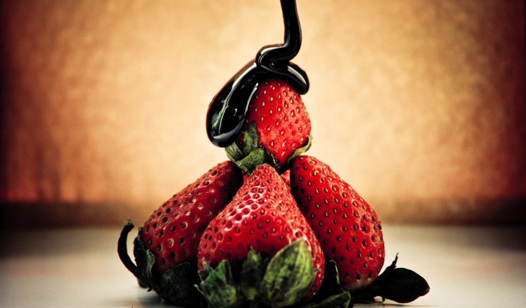 Шоколад льется на клубнику