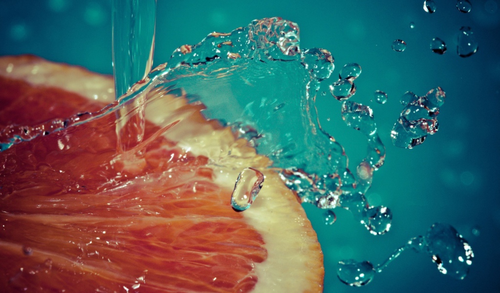 Вода льется на срез грейпфрута