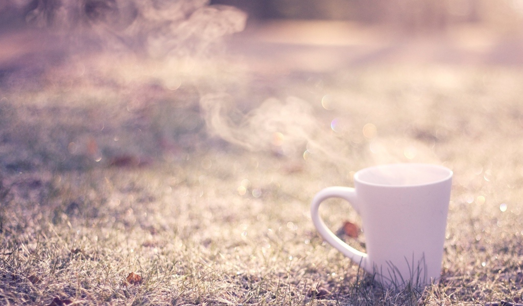 Дымящаяся чашка на траве