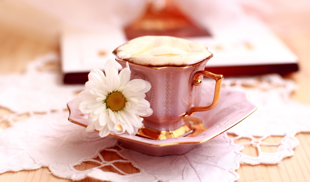 Кофе с пенкой и ромашка на блюдце