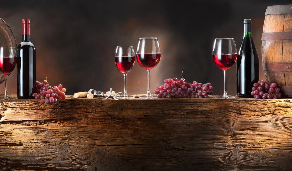 Красное вино и виноград на деревянной подставке