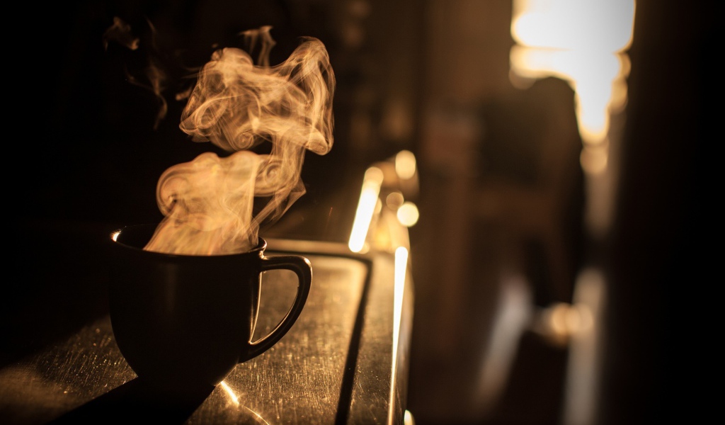 Пар из чашки кофе на закате