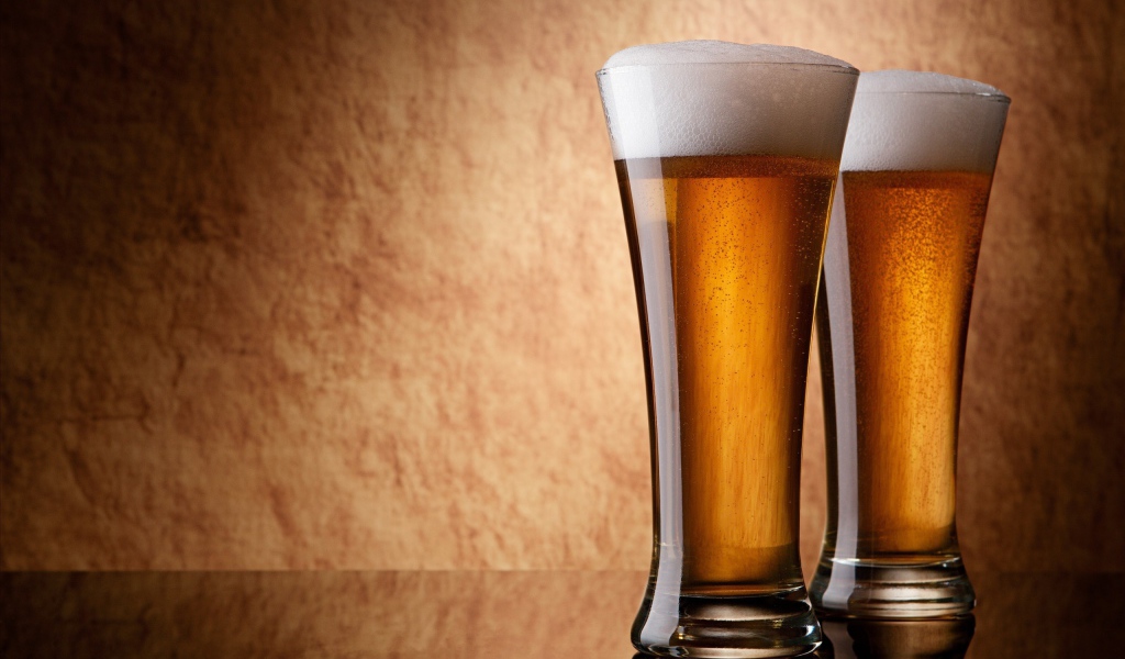 Два бокала пива, коричневый фон