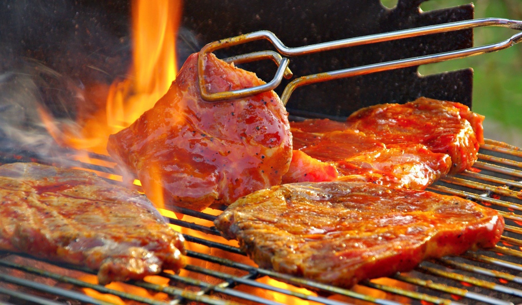 Стейк жарится на огне барбекю