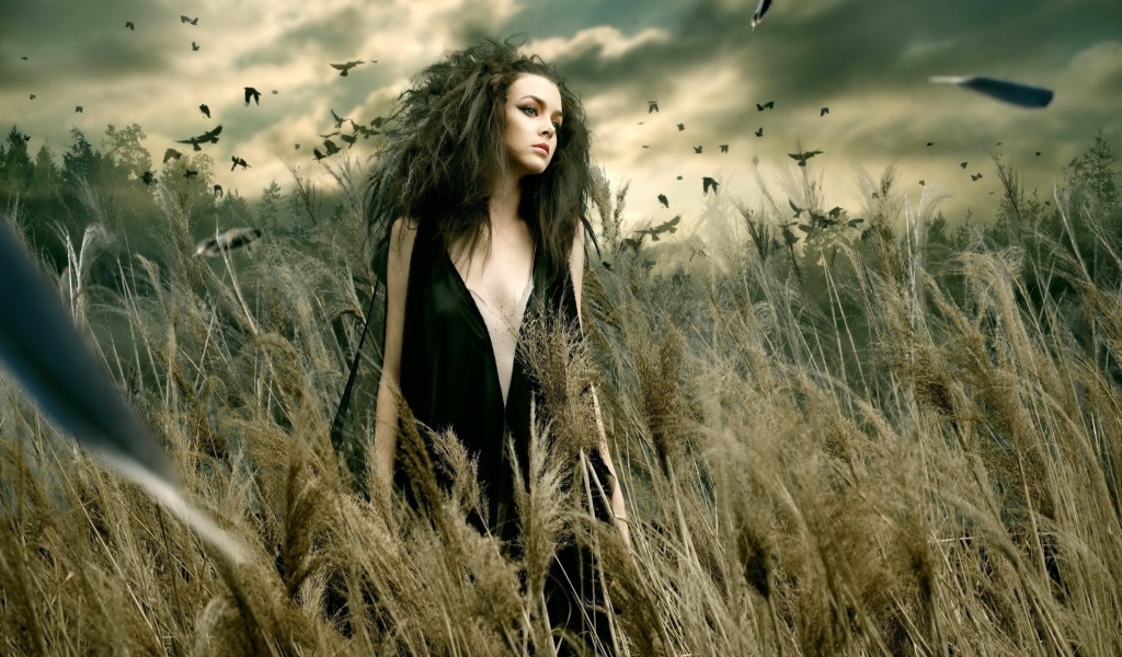 Девушка в поле во время сильного ветра