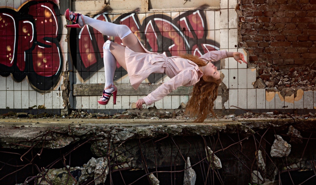 Девушка выполняет трюк на фоне граффити