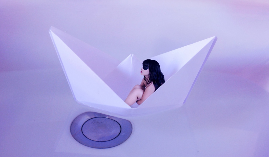 Девушка сидит в бумажном кораблике