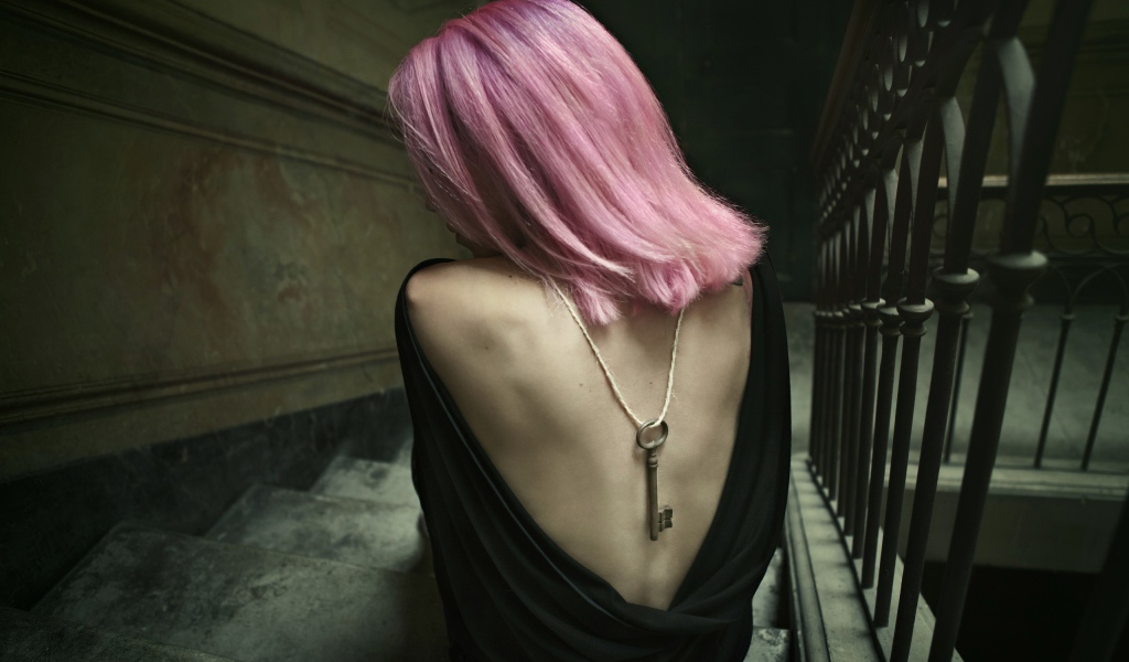 Девушка с розовыми волосами сидит на лестнице