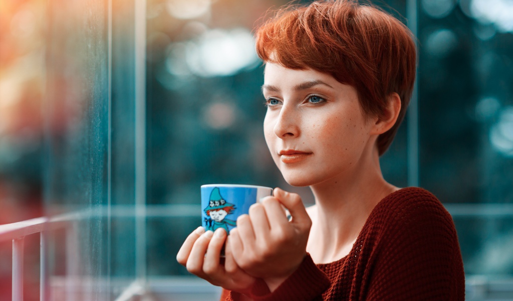 Девушка с короткими волосами пьет кофе