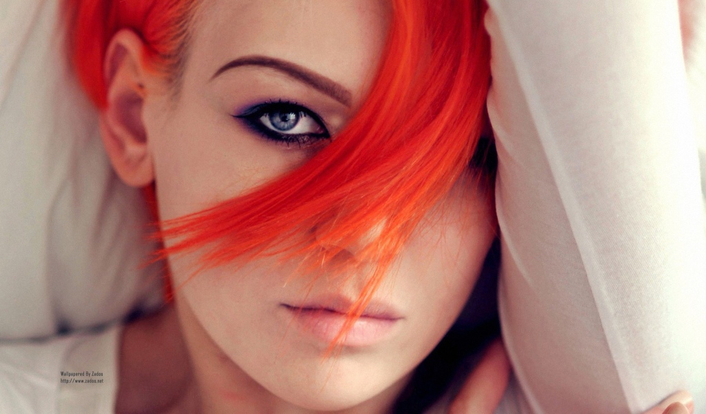 Прядь оранжевых волос на лице у девушки