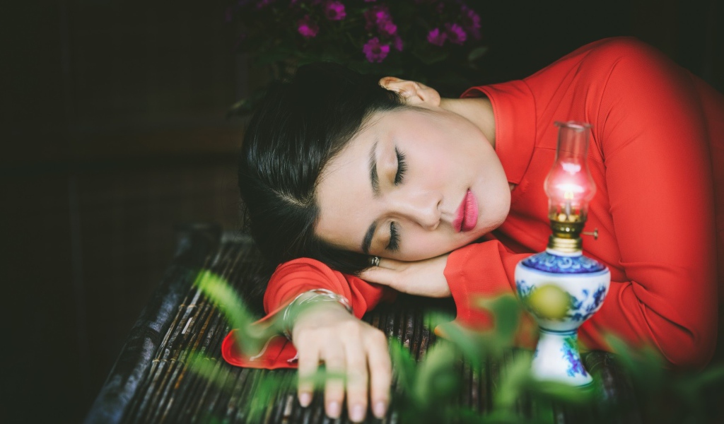 Азиатка спит положив голову на руки