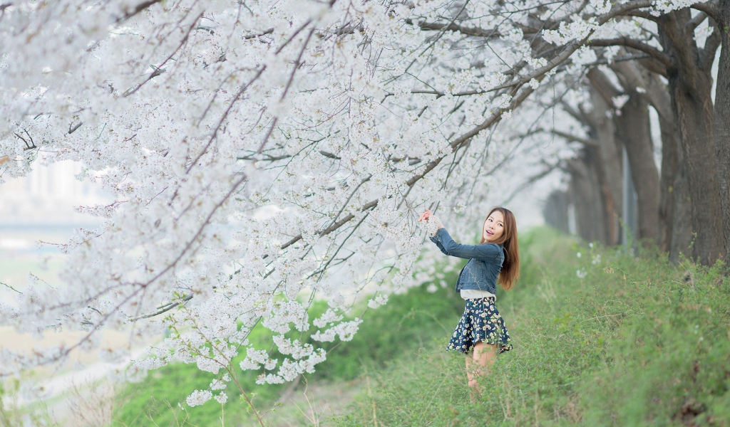 Азиатская девушка радуется весенним цветам