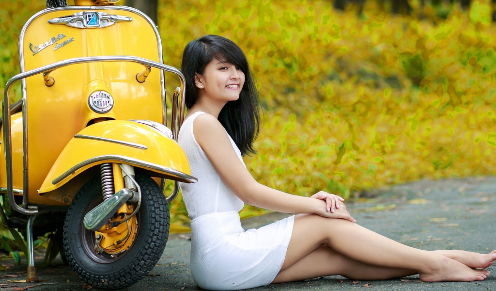 Азиатская девушка у желтого мотороллера