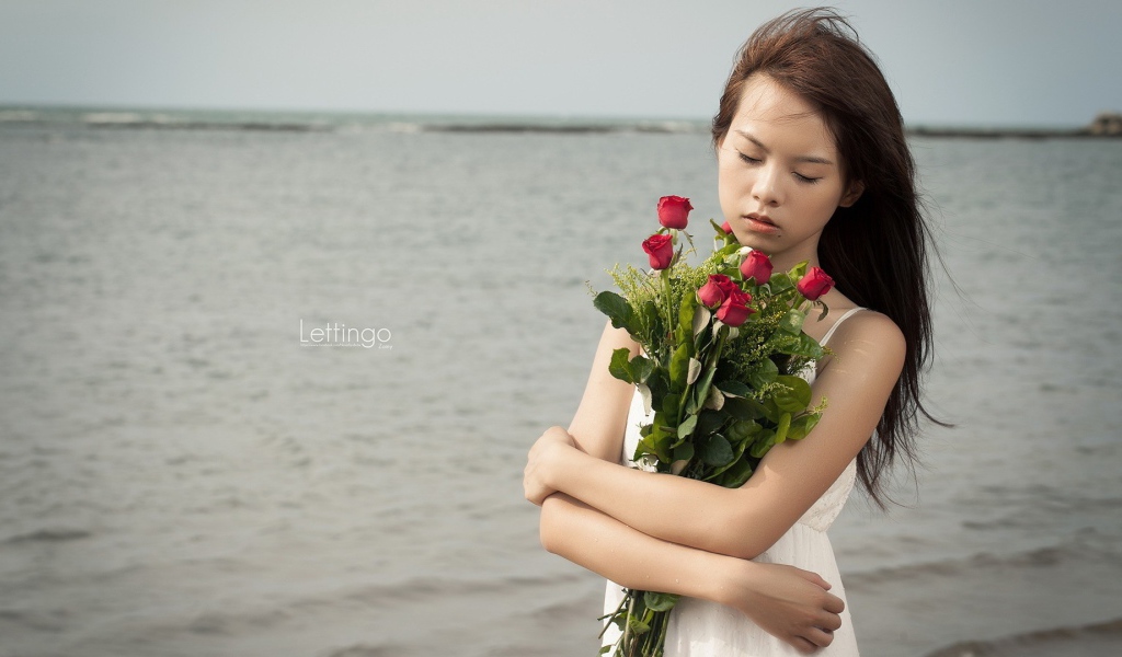 Азиатка держит в руках букет роз