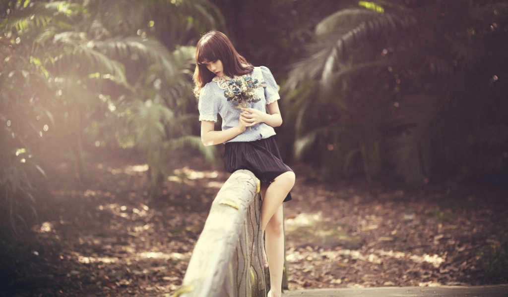 Азиатка с букетом на поручне моста