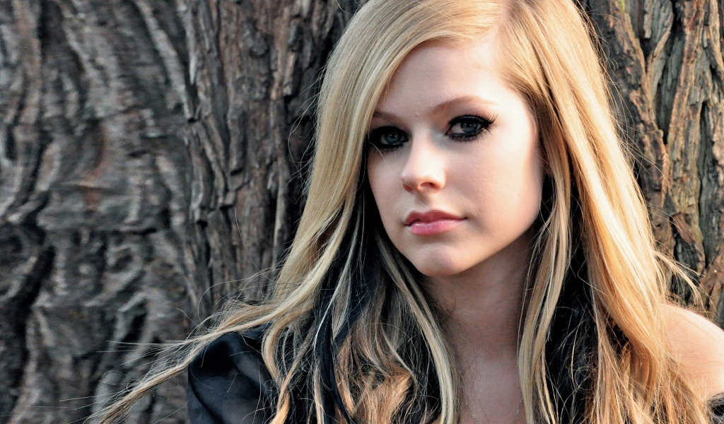 Блондинка Аврил Лавин на фоне коры дерева