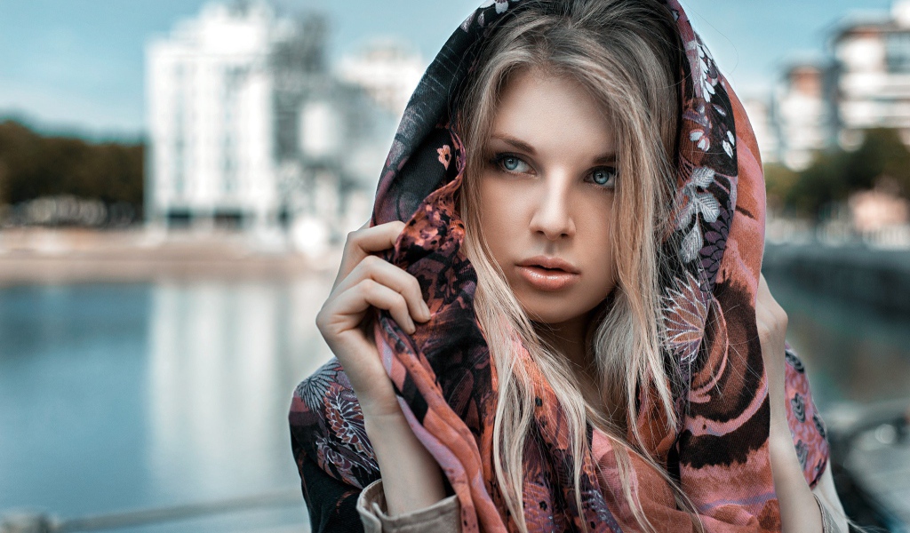 Блондинка в накидке на фоне городского пруда