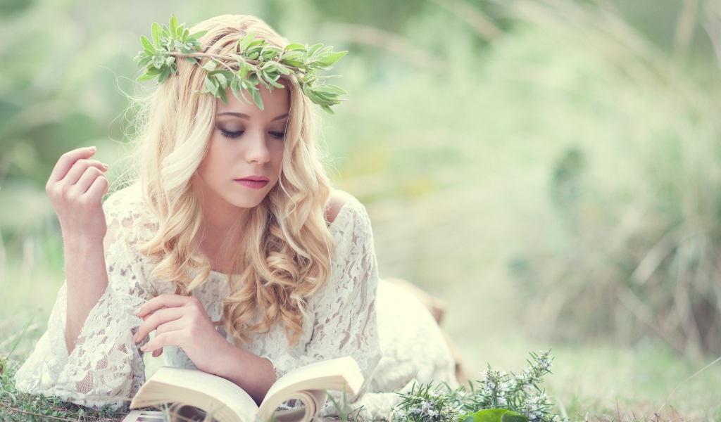 Блондинка в зеленом венке читает книгу
