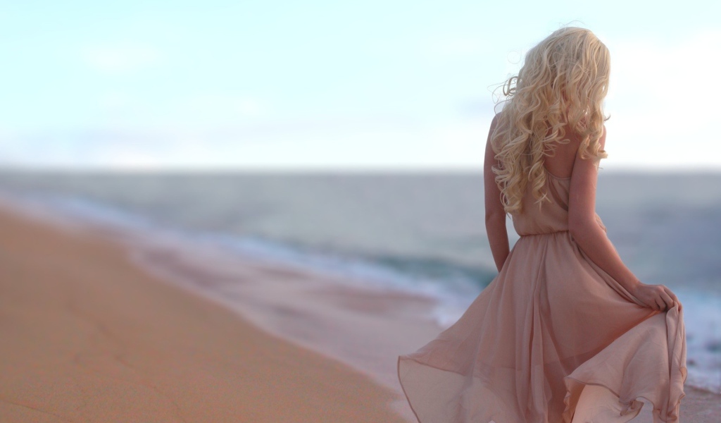 Блондинка в легком платье на пляже