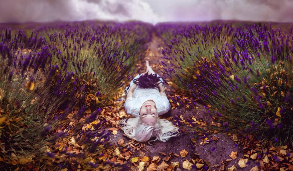 Блондинка лежит на тропе среди поля лаванды