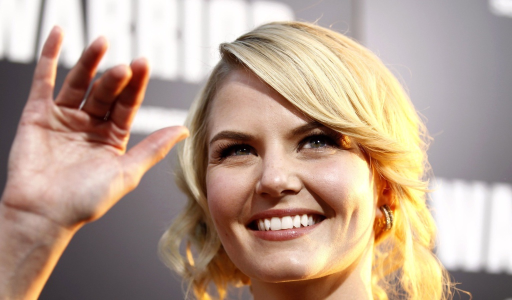 Блондинка улыбается и машет