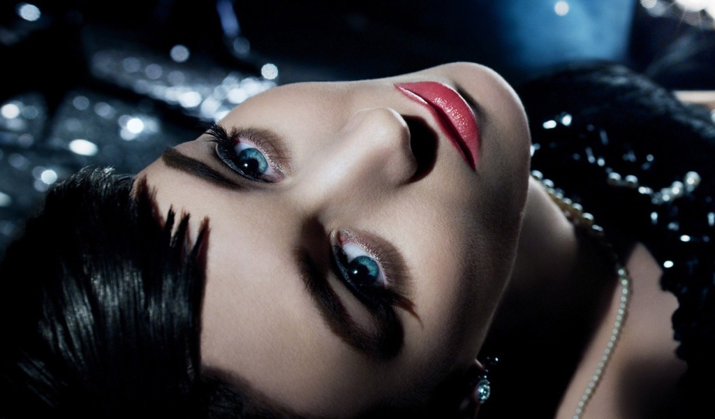 Голубоглазая брюнетка лежит в черном платье