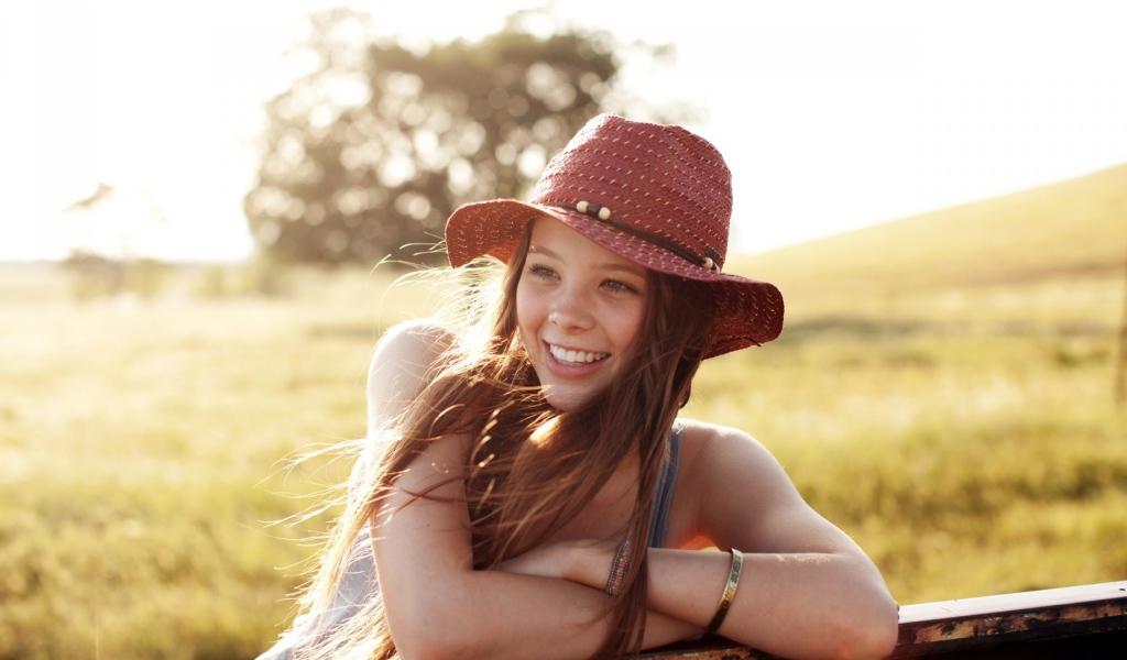 Веселая девушка в легкой красной шляпе