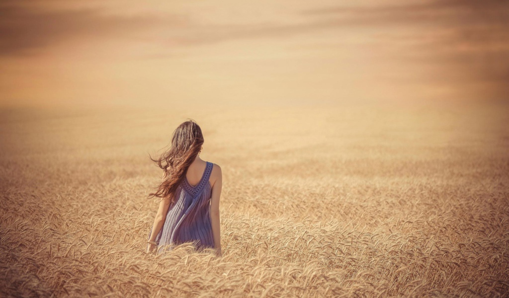 Девушка среди поля спелой пшеницы